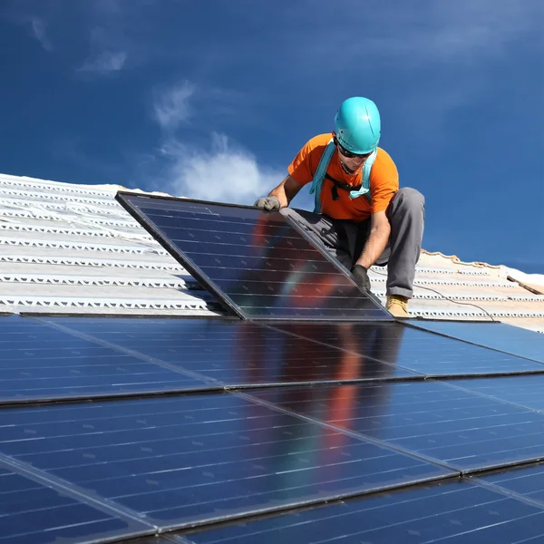 Человек, устанавливающий солнечные батареи — стоковое фото