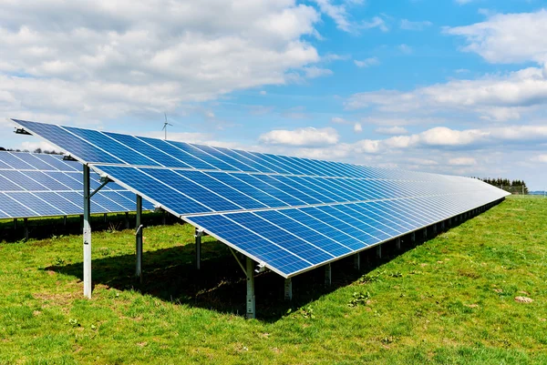 Панели солнечных батарей на зеленом поле — стоковое фото